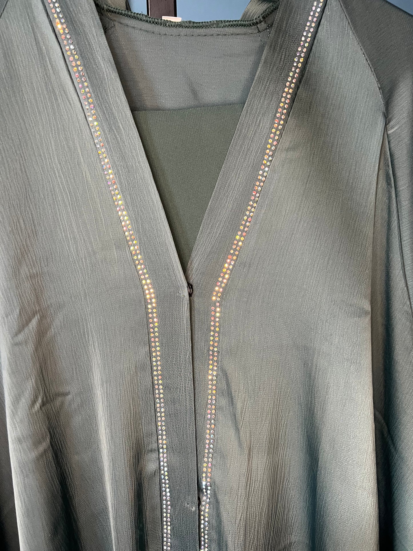 Teal-colored abaya with intricate rhinestone